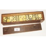 A wooden case of bone dominoes.