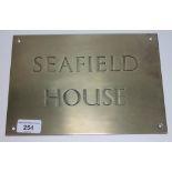 A brass house name plate 'Seafield House', 25.5cm x 17.5cm.