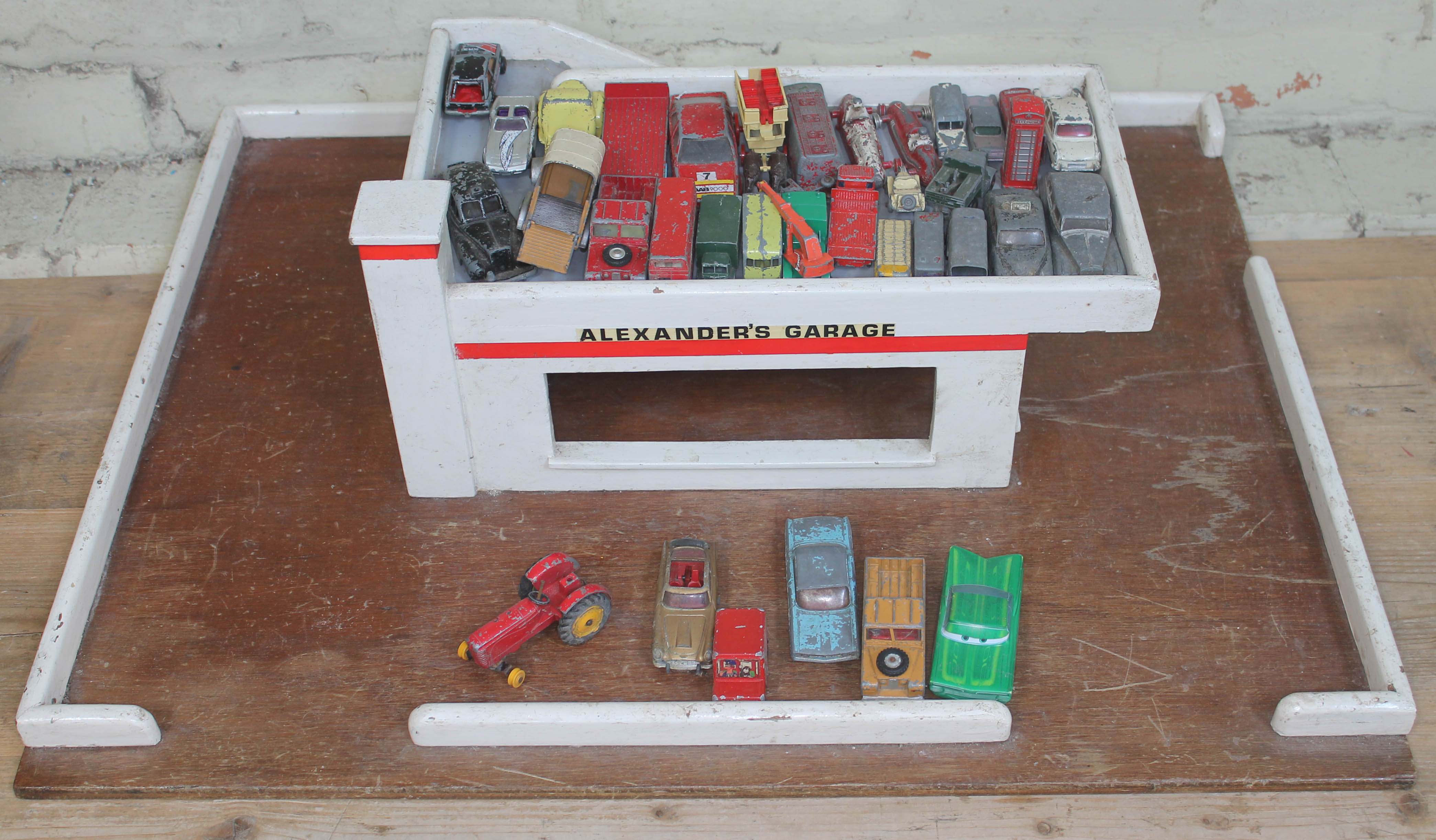 A vintage wooden garage and play worn die-cast model vehicles including Dinky, Corgi and Lesney