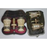 A pair of carved bone opera glasses with leather case and a pair of mother of pearl and brass