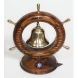 A ship souvenir brass bell and striker within oak wheel frame and oak base labelled 'M.V. Charon' (