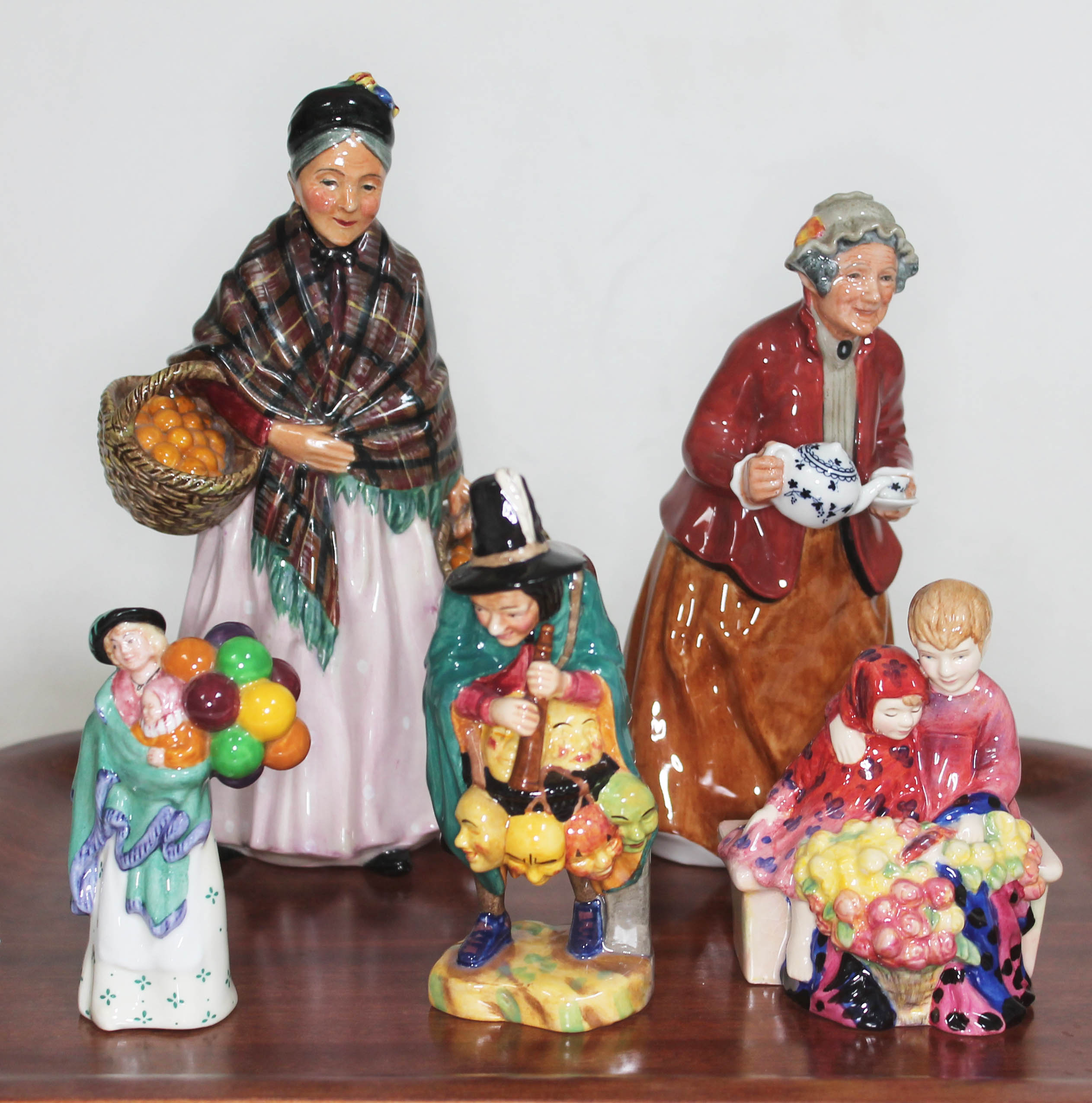 A group of five Royal Doulton figures comprising; The Orange Lady HN1759, Tea Time HN2255, Flower