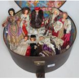 A vintage circular hat box containing various Peggy Nisbet dolls including Henry VIII and various