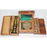 Three cased instruments to include a reproduction military compass, a reproduction boatswain's