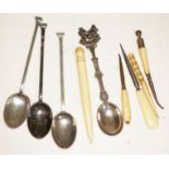 Three hallmarked silver teaspoons, another souvenir spoon, and four bone accoutrements.