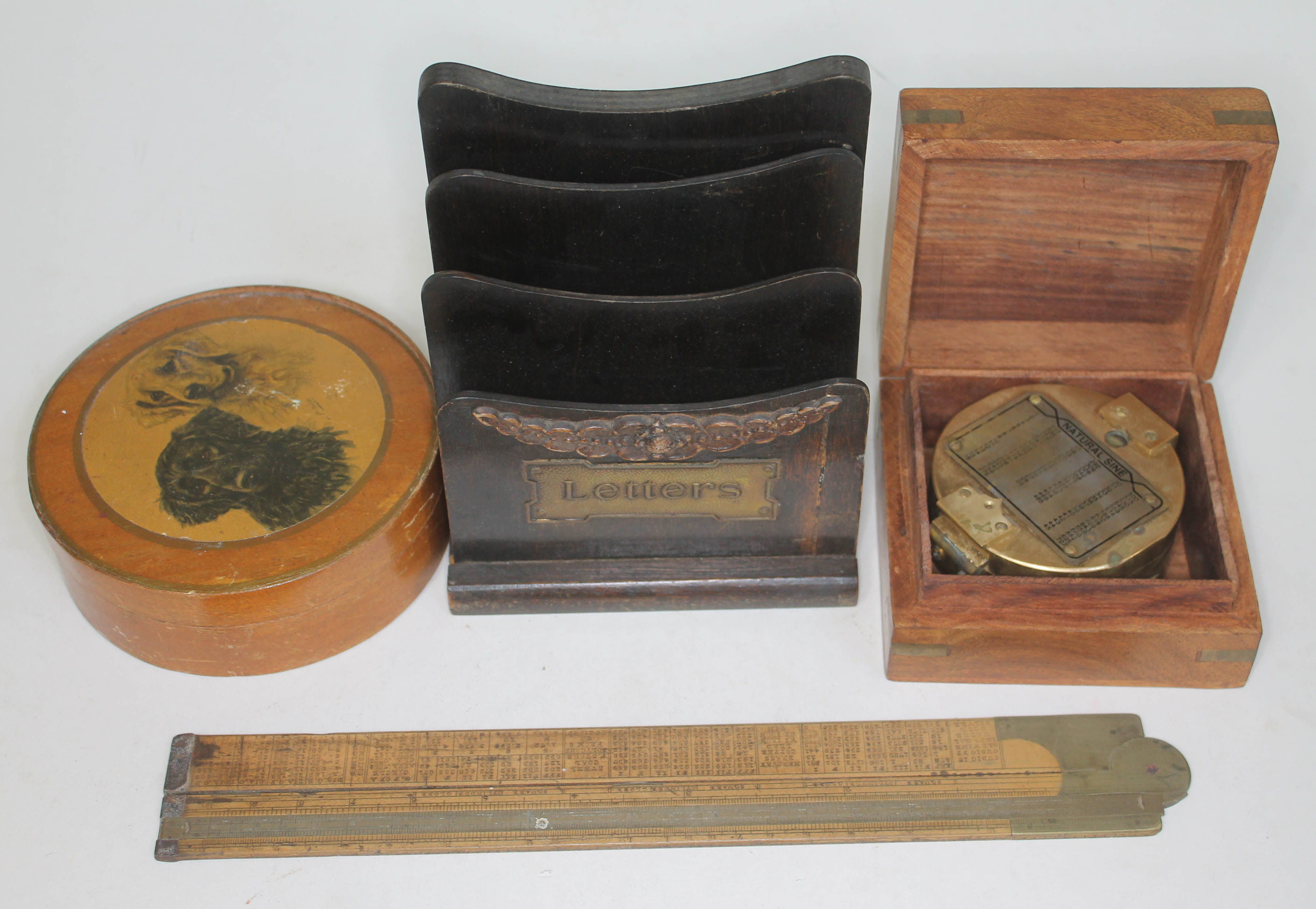 A mixed lot comprising a reproduction brass compass in wooden case, a wooden letter rack, a circular