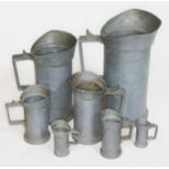 A set of graduated pewter measuring jugs.