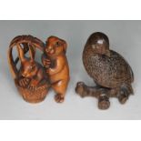 Two oriental carved wooden netsuke, one formed as a bird on branch and the other a pair of rabbits