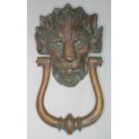 An antique cast brass door knocker formed as a lion's head, length 24cm.