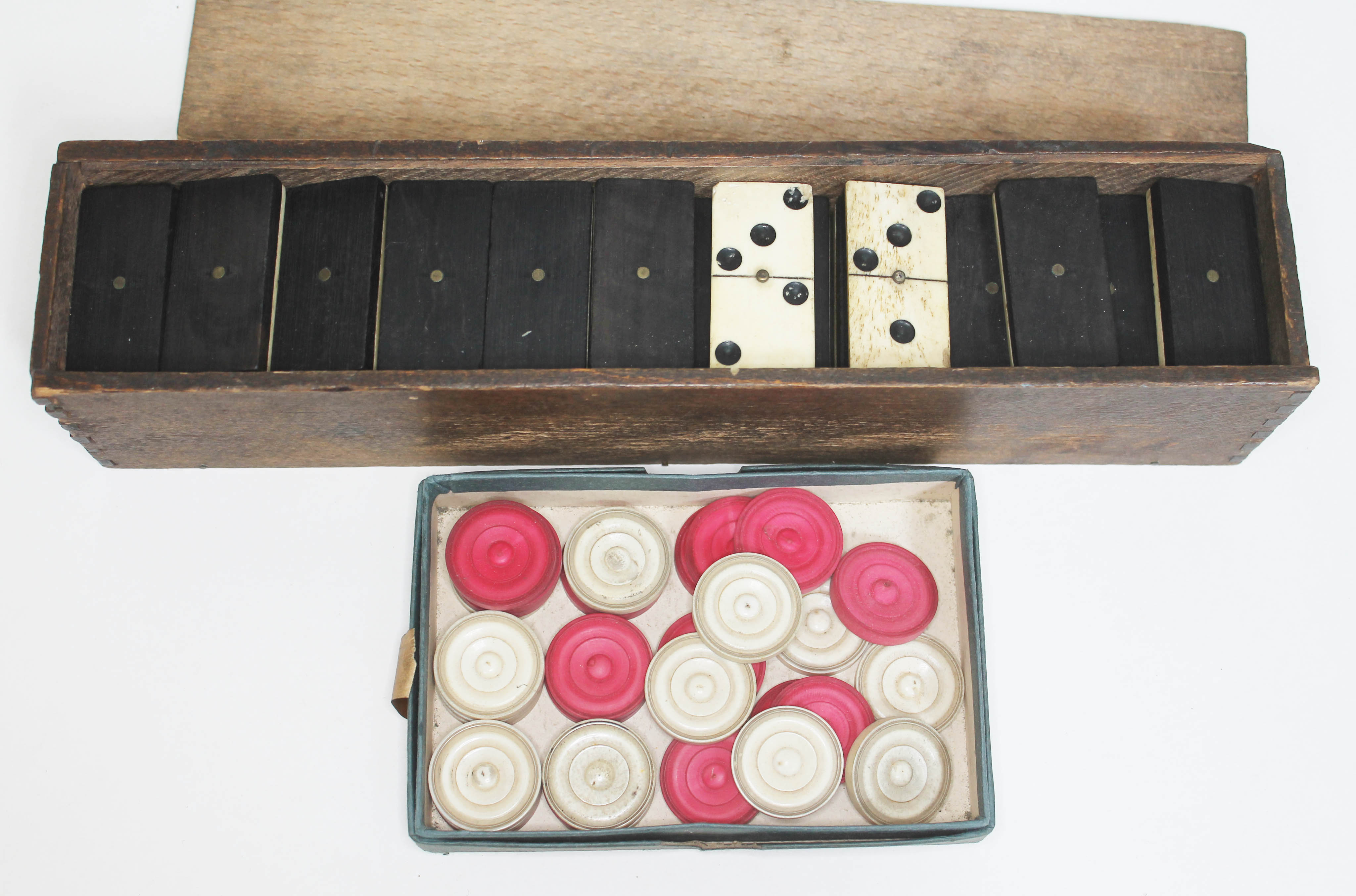 A set of Victorian carved ivory draughts pieces and a set of bone and ebony double nine dominoes