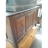 An oak coffer with carved panels