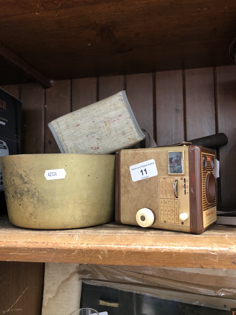 A brass pan and a vintage Kodak Brownie Flash B camera.