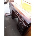 A reproduction pedestal desk with tooled leather top