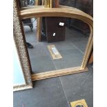 A large oval gilt framed over mantle mirror