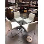 A modern chrome base and glass round top dining table with 4 chairs having cream faux leather
