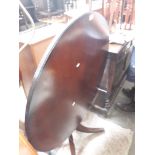 A round tilt top reproduction mahogany table