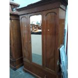 An early 20th century walnut mirror door wardrobe