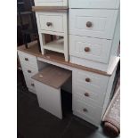 A modern white dressing table with a matching bedside cabinet