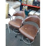 A pair of chrome and rexene swivel stools