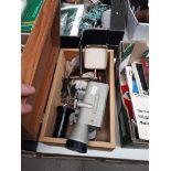 A wooden box containing a theodolite and other scientific instrument accessories.