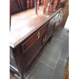 An oak sideboard with rail back, carved panels, barley twist cross stretcher and beadwork