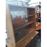 A light oak bookcase with glass sliding doors