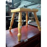 An old yellow painted milking stool