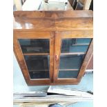 A glazed walnut display cabinet.