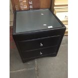 A modern faux leather and glass top bedside cabinet