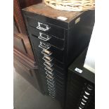 A vintage black metal multi drawer filing cabinet