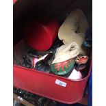 A red case with contents including hats and handbags