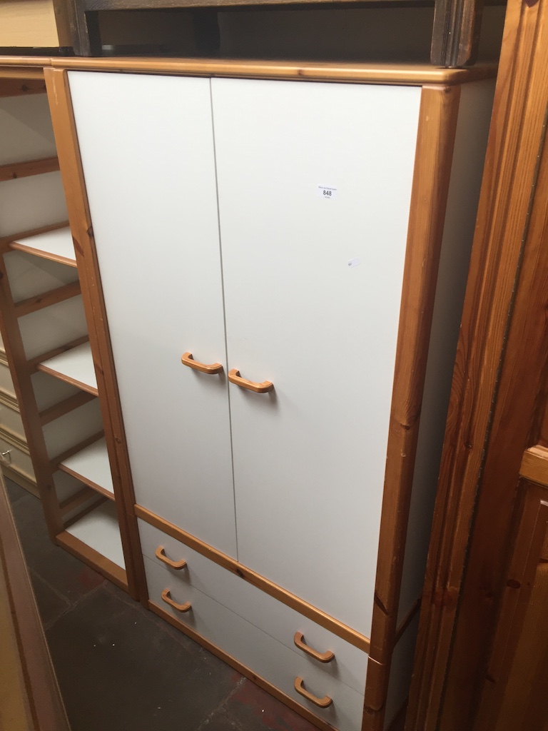A pine wardrobe with white doors together with a matching shelving unit