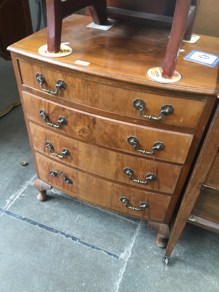 A reproduction walnut bow front chest of drawers