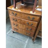 A reproduction walnut bow front chest of drawers