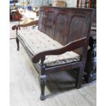 An 18th century Lancashire oak settle with panelled back, scroll arms and cabriole front legs, width