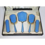 A cased Art Deco hallmarked silver and blue enamel dressing table set.