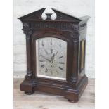 An Edwardian oak mantle clock with architectural cornice, Corinthian columns, steel dial with