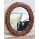 A 19th century Gothic Revival mixed wood oval mirror, 57cm x 66cm.