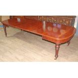 A mahogany wind out table circa 1850, D ends, turned and fluted legs terminating on gilt brass and