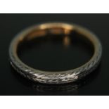 A two colour wedding band with chevron type engraving, marked '18BKt', wt. 3.12g, size M.