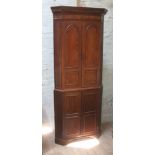 A Georgian mahogany free standing corner cabinet with dentilated cornice, fluted faux columns,