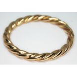 A 9ct gold twist bangle, with 9ct gold import marks, diam. 6.5cm, wt. 22.18g. Condition - good, no