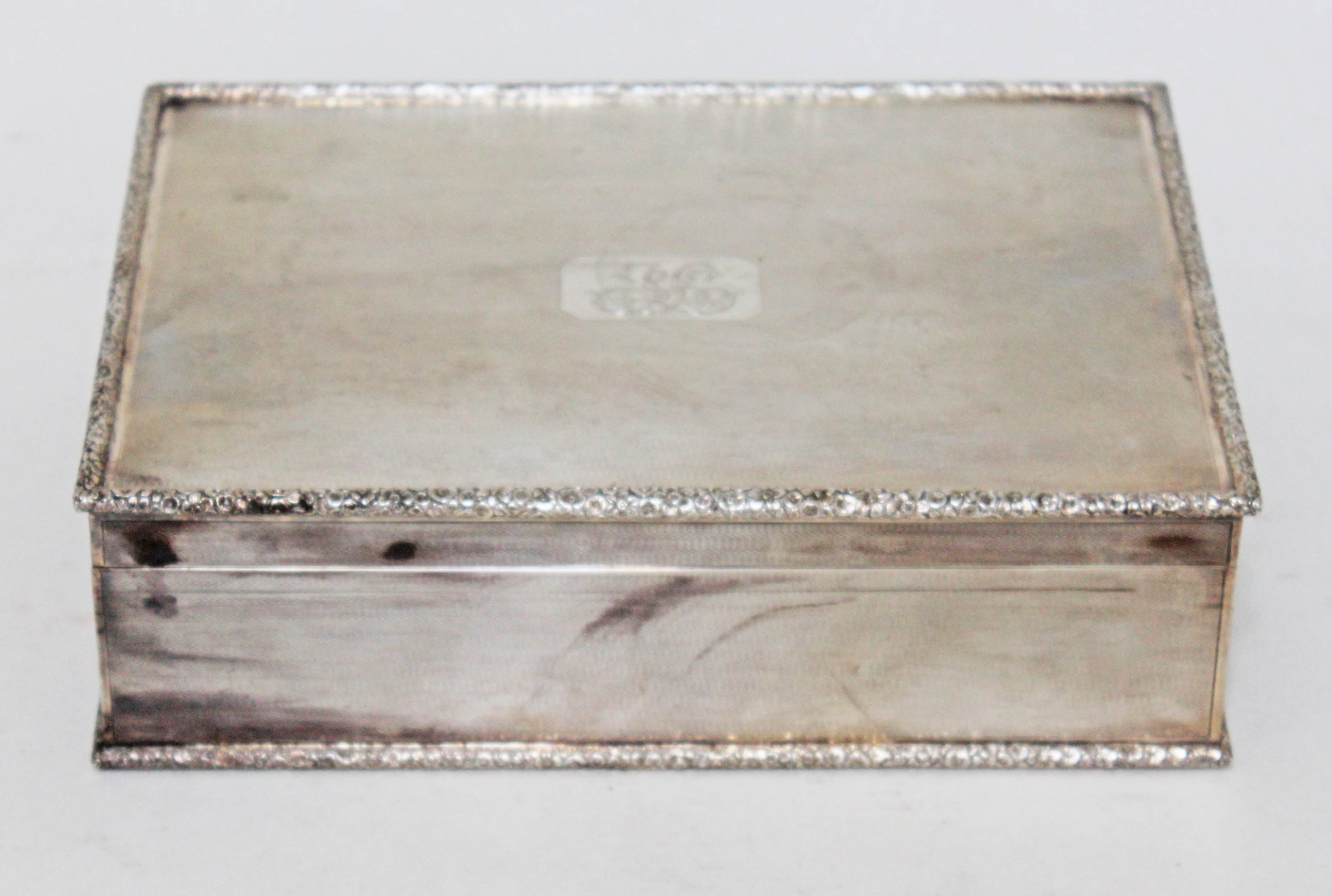 A George VI silver cigar box, textured exterior with floral moulded border, gilt interior, cedar