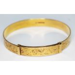 A hallmarked 18ct gold bright cut engraved and adjustable bangle, wt. 30.93g. Condition - good, no