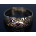 A hallmarked 18ct gold, scroll setting set with colourless and red stones, gross wt. 1.78g, size K.