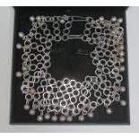 A contemporary silver collar necklace formed as linked rings with drop spheres, length approx. 41cm,