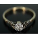 A single stone diamond ring, white metal illusion setting with millegrain detail, band marked '9ct',