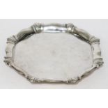 A hallmarked octagonal shaped salver raised on four bun feet, Joseph Gloster Ltd, Birmingham 1923,