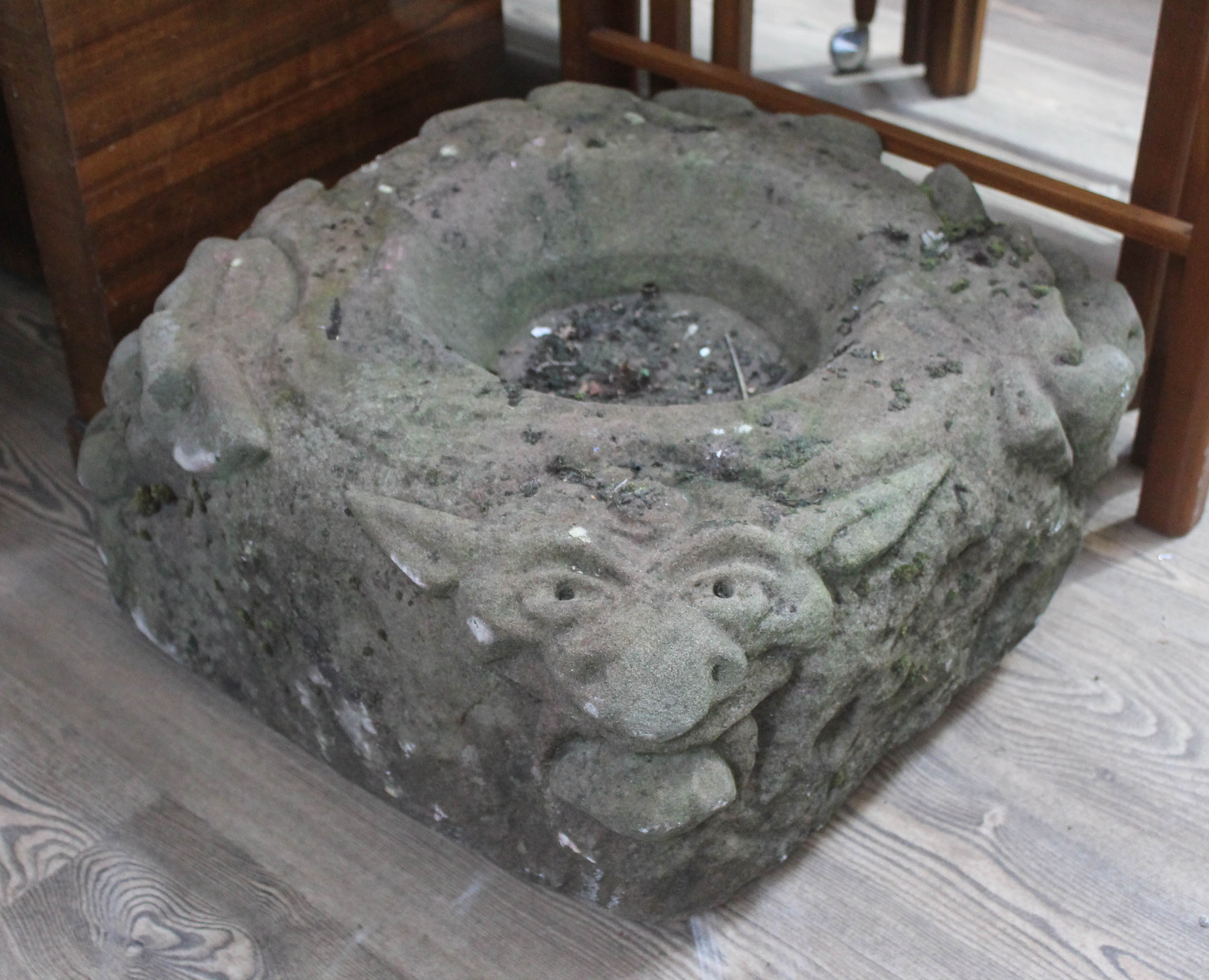 An antique carved sandstone water feature with spouting gargoyles, approx. 50cm x 50cm.