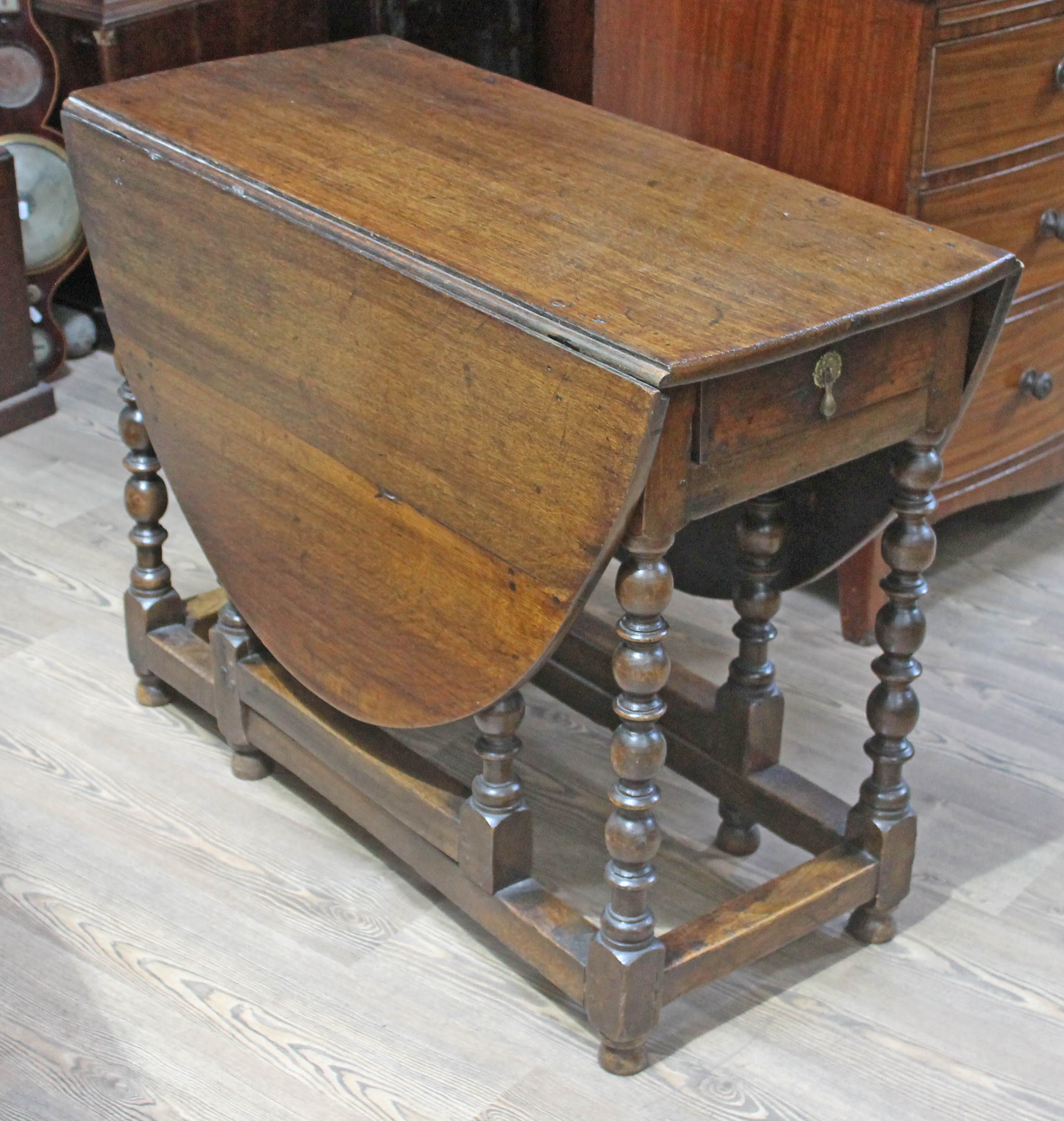 An 18th century oak gate leg table with bobbin legs, min. length 103cm, width 46cm & height 76.5cm.